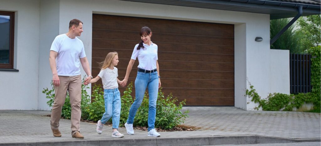 Family in front of a modern garage door - faux wood appearance